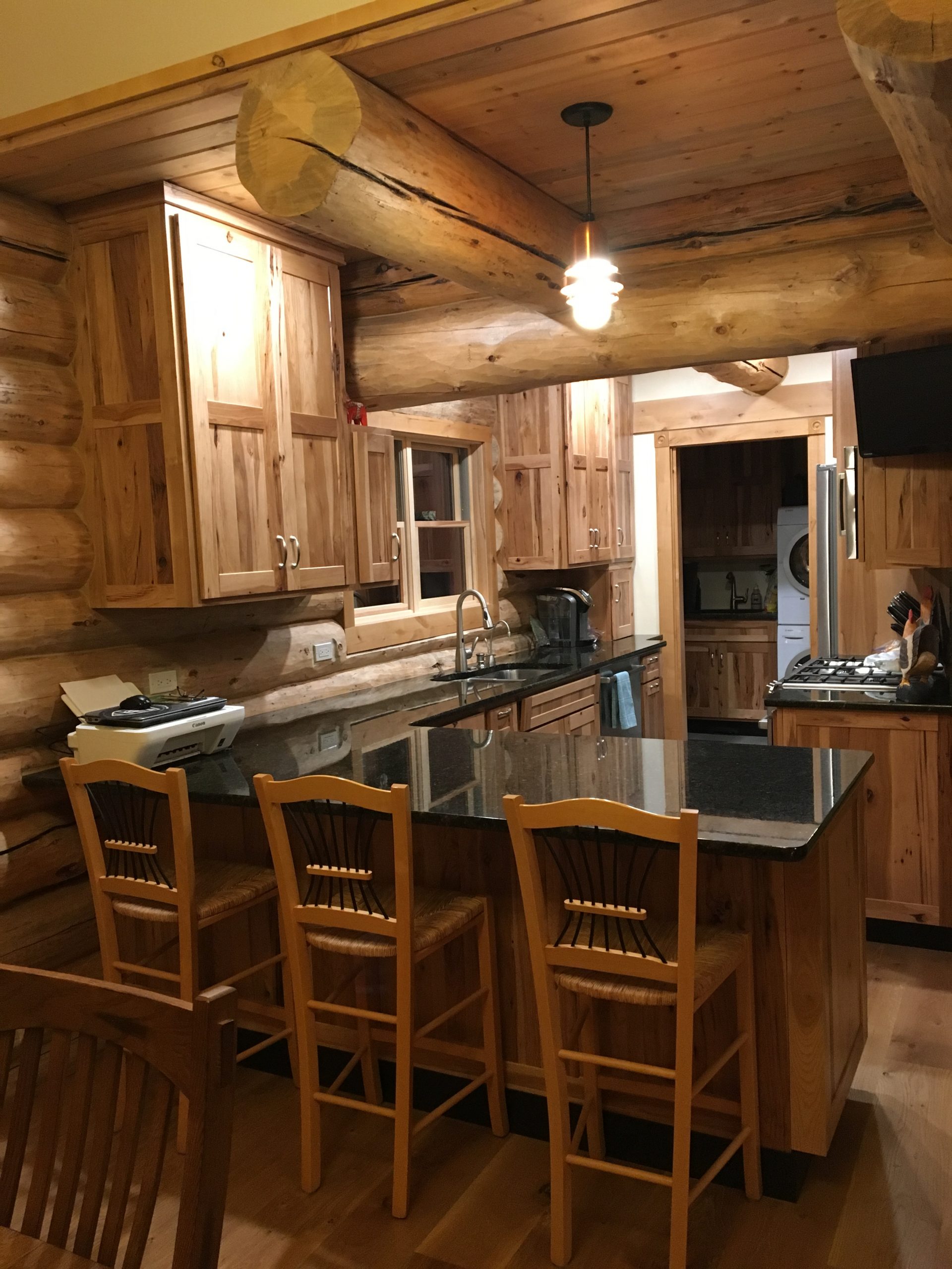 A small but efficient kitchen has custom cabinets and granite counter tops in this log home.