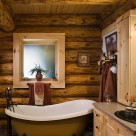 Clawfoot tub in bathroom of handcrafted log home