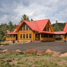 Exterior log home with red metal roof
