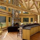Great room in handcrafted log home with prow window wall and log truss