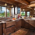 Custom log home kitchen with copper sink surrounded by dark cabinets. 8' window above sink has views to glacier national park.