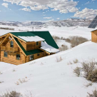 Log home with shed dormers in winter