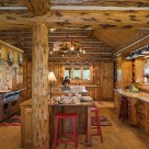 Kitchen with red bar stools in handcrafted chink style log home.