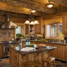 Gorgeous kitchen with granite countertops custom cabinetry slate flooring and copper range hood in custom log home.