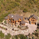 Aerial view of luxury log home with log guesthouse attached by breezway on mountainside in Steamboat Springs Colorado.