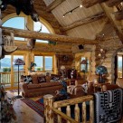 Great room in handcrafted log home with french doors and arched top windows viewing the Colorado mountains