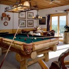 Custom log pool table with western light above and french door with view of Colorado mountains.