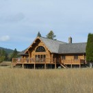 Exterior of handcrafted log home with large deck and log railings