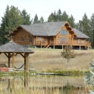 Montana Log Home viewed across pond with log gazebo