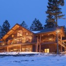Twilight photo of luxury log home in winter.
