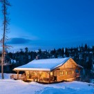 Stunning twilight photo of dovetail log cabin in winter.