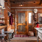 Interior photo of antique wood door in chink style log cabin.