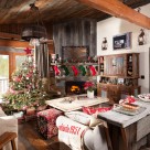 Living room of log cabin decorated with Christmas tree and stockings.