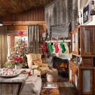 Living room with antique hutch, Christmas tree and Christmas stockings hung on mantle of fireplace.