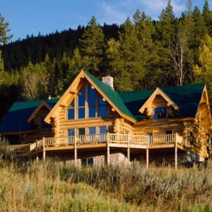 Exterior of handcrafted log home with green metal roof