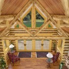 Rendering view from loft level of custom log home with truss and stone fireplace.