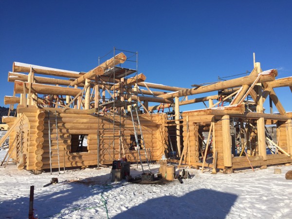 Snow doesn't stop the completion of this Scandinavian full scribe log home package.