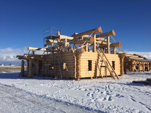 Snow covers the ground, but construction is till underway to complete this handcrafted log package.