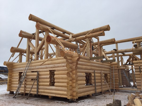 A finished log package with flared butt cedar roof system awaits tear down and loading onto interstate carriers.