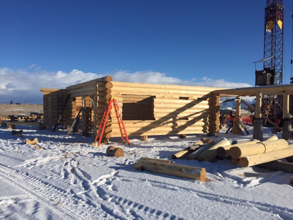 Fresh snow doesn't stop the building of this handcrafted log home.