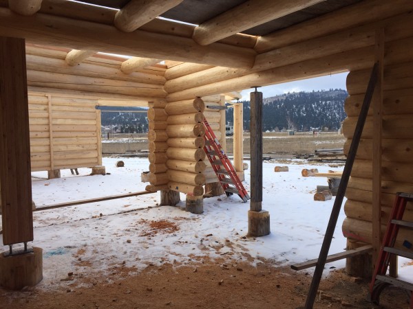 The interior of this Scandianvian full scribe log home shows the stringer logs, joists, and infill logs for the loft floor.