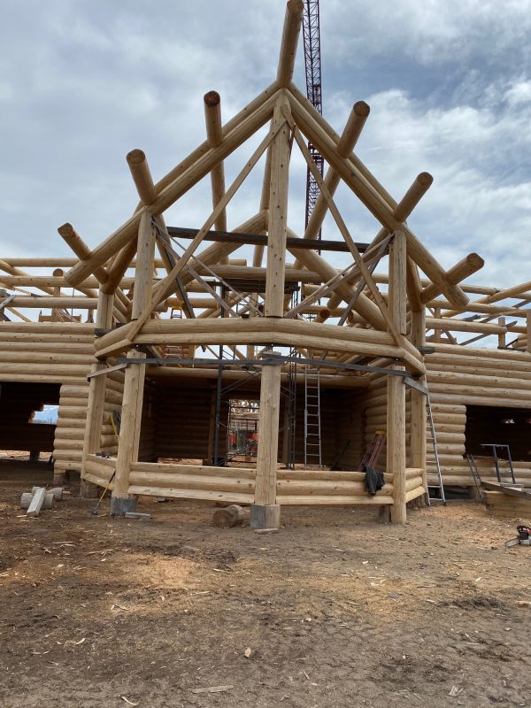 This full scribe log package has excellent example of log fly rafters and log columns to support the purlins and ridge.