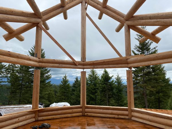 The homeowners will enjoy the view through the massive windows of the great room bay in this log home.