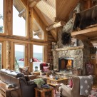 Log home living room with stone fireplace and cozy couch