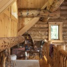 Log home loft with log railings and custom boat shaped book case.