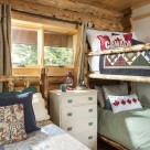 Log home bedroom with log bunkbed and custom quilts