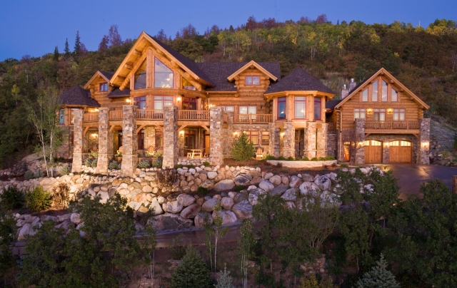 Stone and hand carved log work make a stunning image of this handcrafted log home.